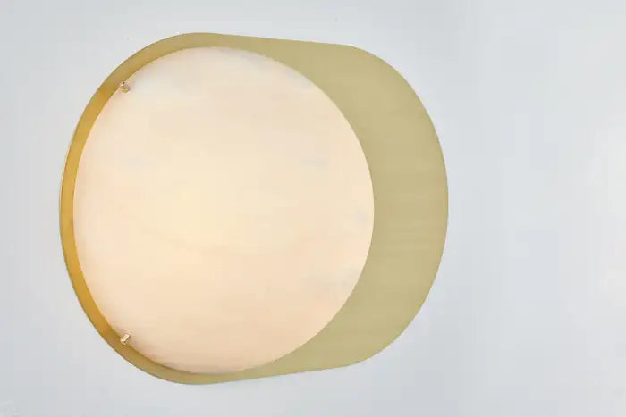 Toogle sconce with round alabaster surface and offset metal plate