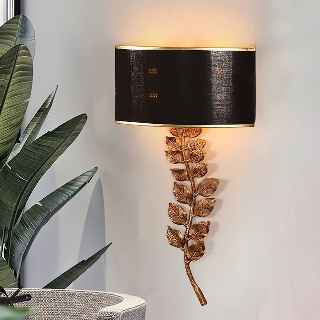 Birdwood wall light with a dark shade and gold-toned leaf stem