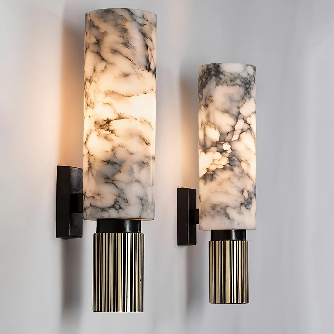 Moni wall sconces with veined pale cylinders above dark ribbed metallic details