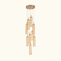 A modern multi-light linear chandelier with multiple clear glass cylinder shades of varying lengths, suspended from a circular gold-toned ceiling canopy by thin metal rods.