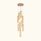 A modern multi-light linear chandelier with multiple clear glass cylinder shades of varying lengths, suspended from a circular gold-toned ceiling canopy by thin metal rods.