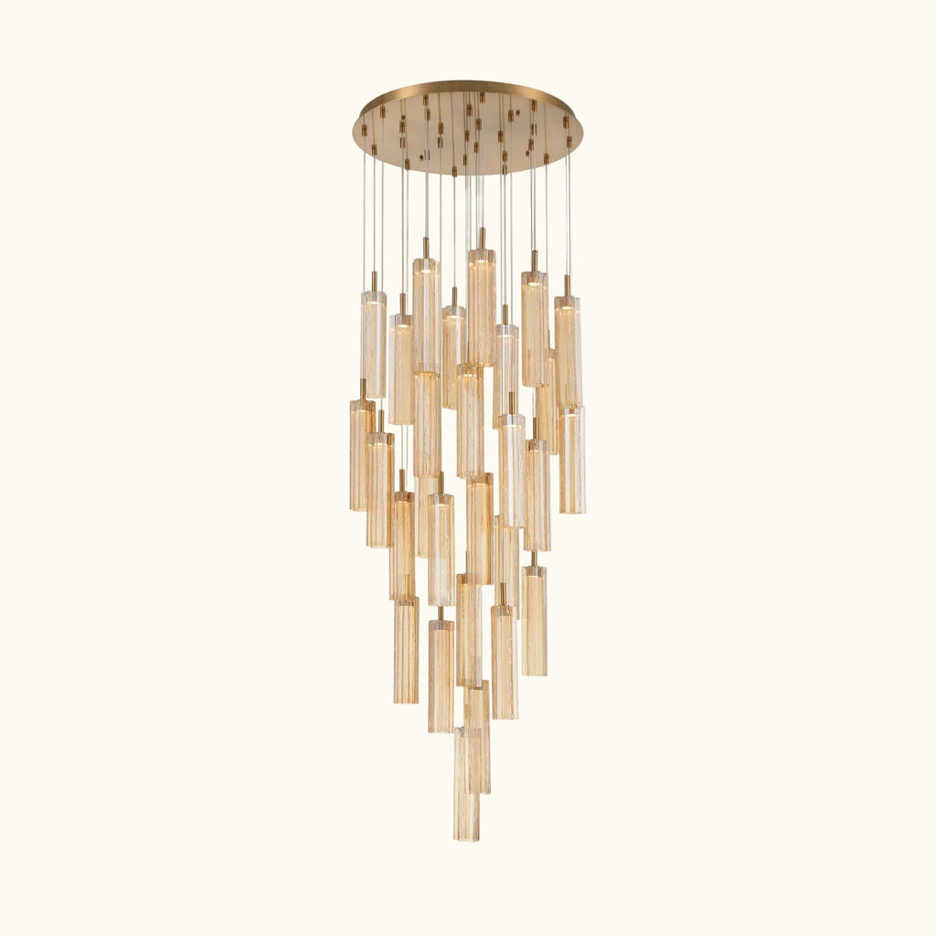 A modern multi-light chandelier with a brushed gold circular canopy and multiple clear glass cylinder shades of varying lengths, suspended against a plain white background.
