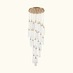 A modern multi-light linear chandelier with a brushed gold circular canopy and multiple clear glass cylindrical tubes of varying lengths, suspended against a plain white background.