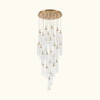 A modern multi-light chandelier with a brushed gold circular ceiling canopy and multiple clear glass cylinder tubes of varying lengths, suspended against a solid white background.