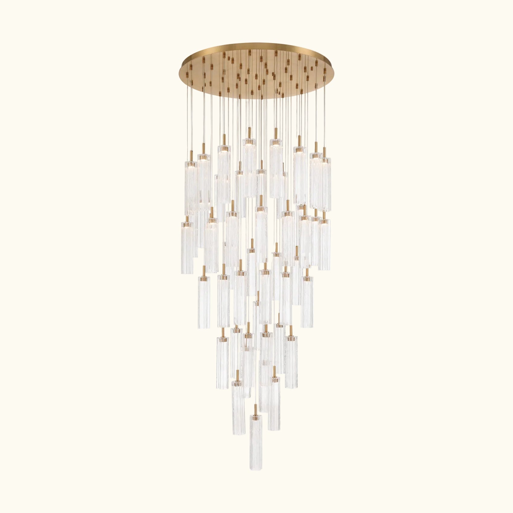 A modern multi-light chandelier with a brushed gold circular canopy and multiple clear glass cylinder tubes of varying lengths, suspended against a solid white background.