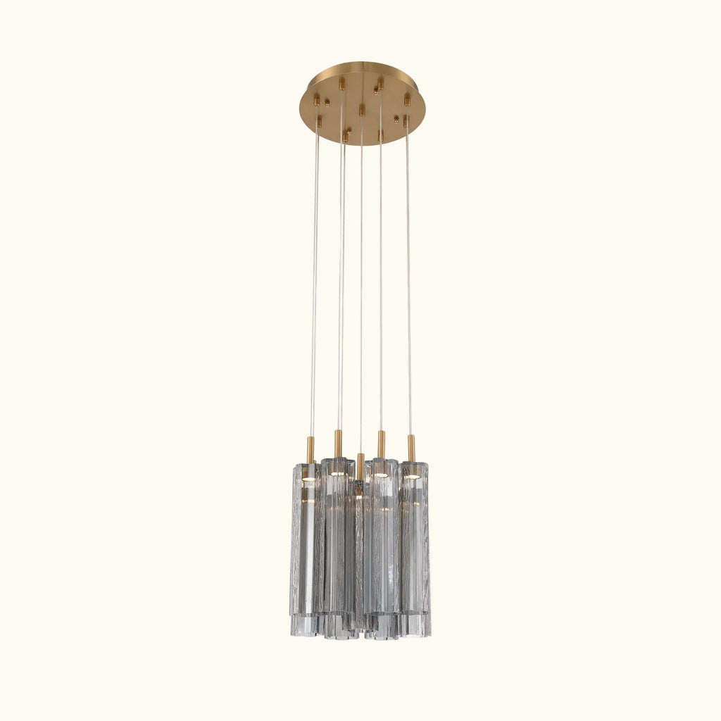 Modern pendant light with gold fixture and clear cylindrical shades on a white background