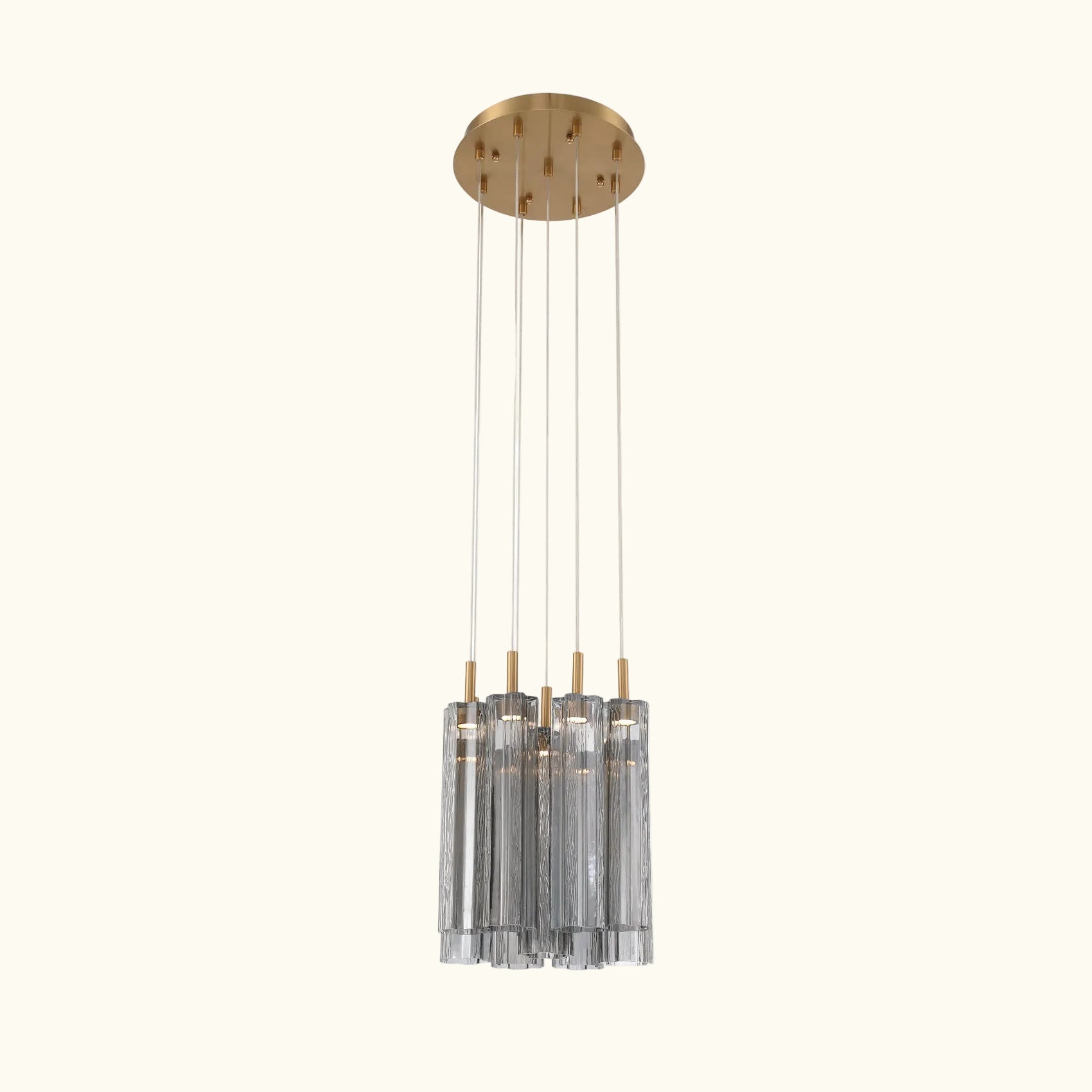 Modern pendant light with gold fixture and clear cylindrical shades on a white background
