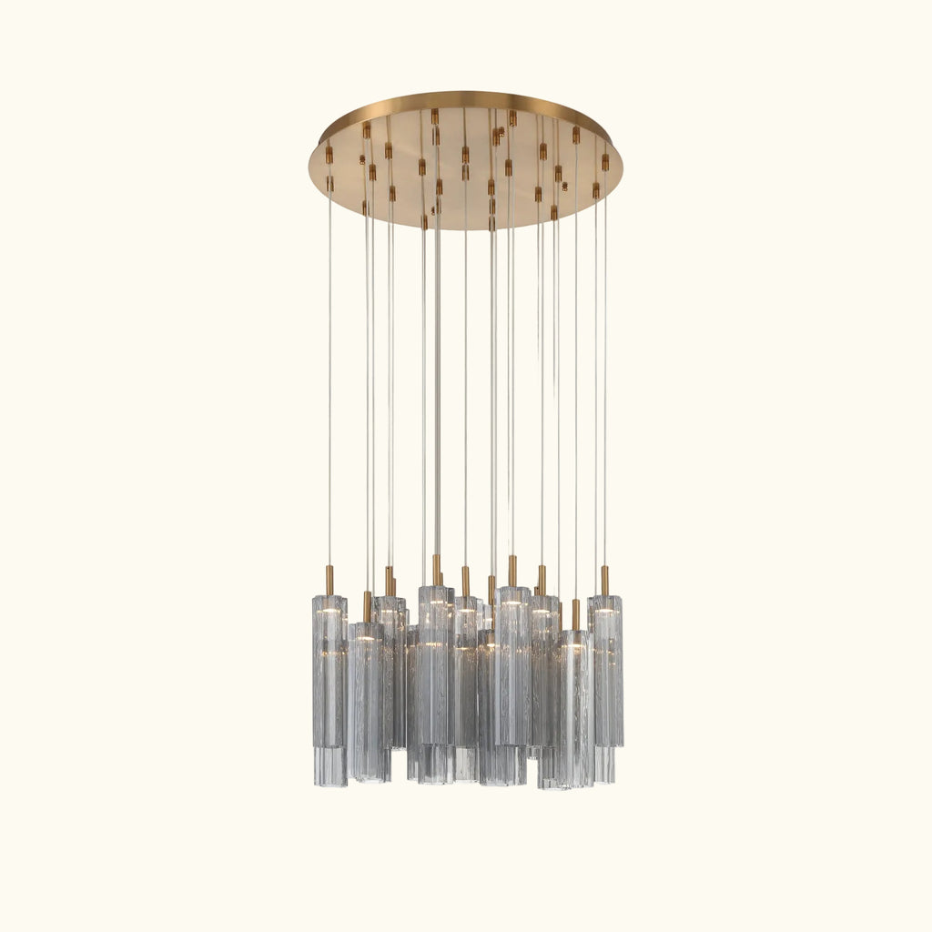 A modern multi-light linear chandelier with a brushed gold circular canopy and multiple clear glass cylinder shades suspended by thin rods, shown against a plain white background.