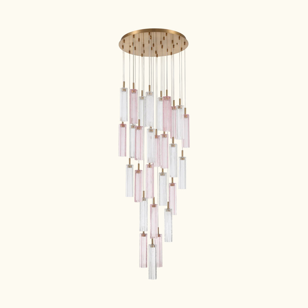 A modern multi-light chandelier with a round gold-toned ceiling canopy, featuring multiple clear glass cylinder shades and several pink-tinted glass tubes suspended at varying lengths against a white background.