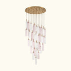 A modern multi-light linear chandelier with a brushed gold circular canopy and multiple clear glass tubes with a soft pink tint, suspended against a solid white background.