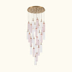 A modern multi-light linear chandelier featuring a round brushed gold ceiling canopy, clear glass tubes, and pink-tinted glass tubes suspended in a cascading, tiered arrangement.