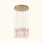 A modern multi-light linear chandelier with a circular gold-toned ceiling canopy, multiple thin vertical rods, and clear glass shades with a soft pink tint, shown against a plain white background.
