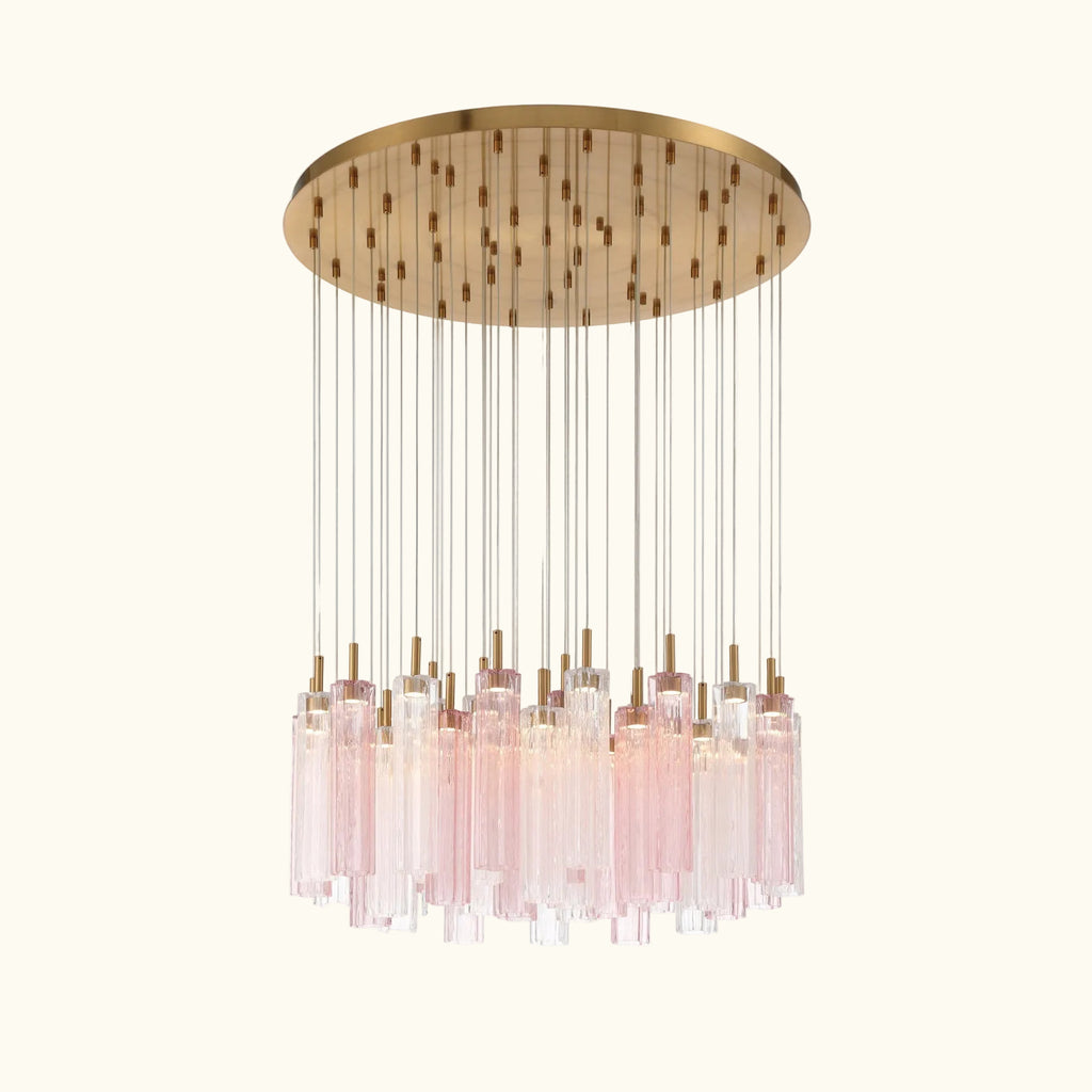 A modern multi-light chandelier pendant fixture with a circular brushed brass canopy, clear glass rods, and multiple pink-tinted glass cylinder drops, shown against a solid white background.