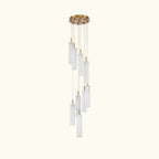 A modern multi-light linear chandelier with a brushed gold ceiling canopy and multiple cylindrical frosted glass shades of varying lengths, suspended against a solid white background.