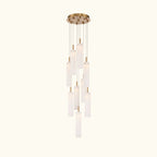 A modern multi-light linear chandelier with a brushed gold ceiling canopy and multiple cylindrical frosted glass shades of varying lengths, suspended against a solid white background.