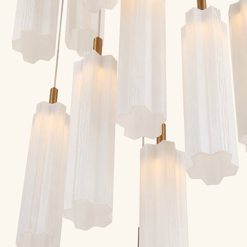 Chandelier with white glass shades and gold fixtures on a light gray background