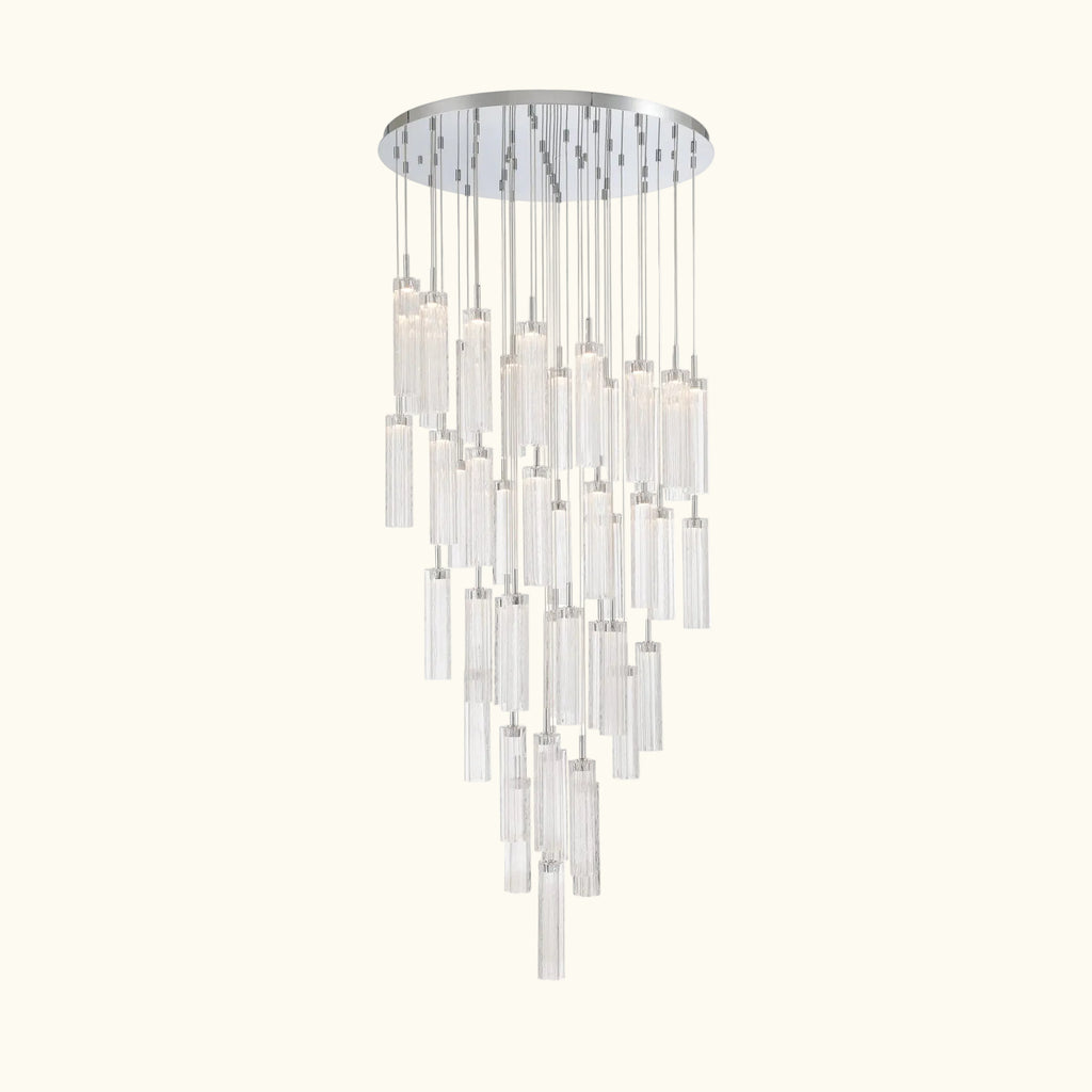 A modern multi-light chandelier with a circular silver ceiling canopy and multiple clear glass cylinder shades of varying lengths, suspended against a plain white background.
