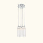 A modern multi-light linear pendant chandelier with a polished silver ceiling canopy and six clear glass cylindrical shades, shown against a plain white background.