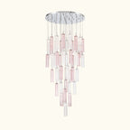 A modern multi-light chandelier featuring a circular silver chrome ceiling canopy with multiple vertical glass shades in alternating translucent pink and clear finishes, suspended against a solid white background.