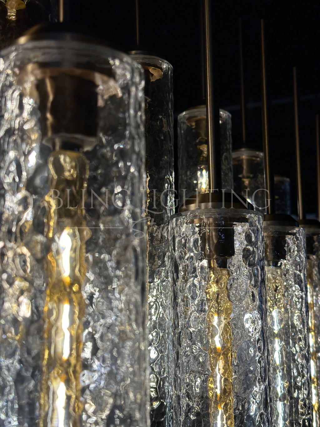 Close-up of textured hammered glass cylinders on the Colleena linear chandelier