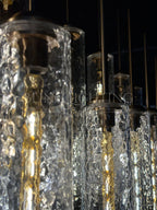 Close-up of textured hammered glass cylinders on the Colleena linear chandelier