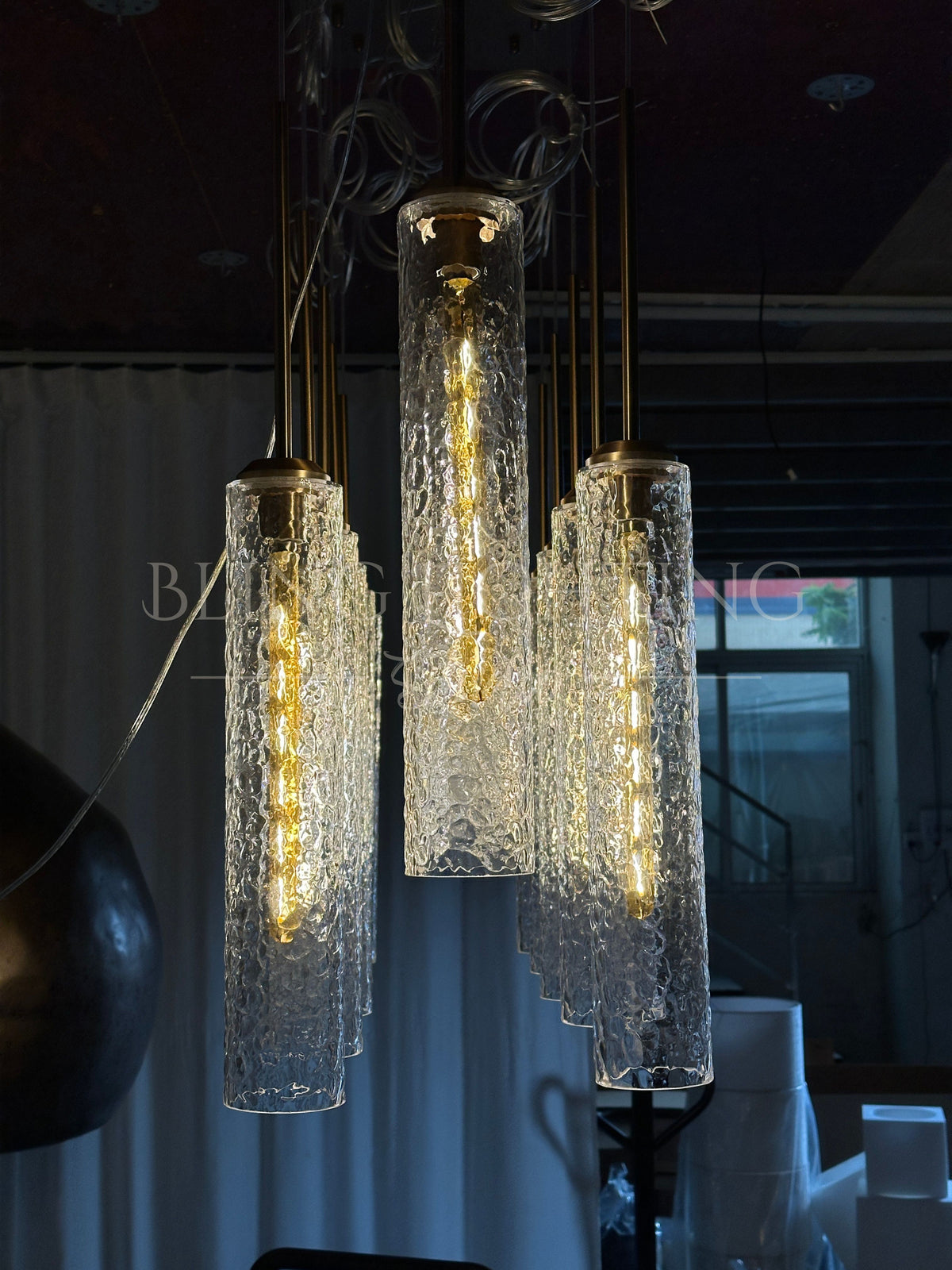 End view of the Colleena linear hammered glass chandelier with layered glowing cylinders