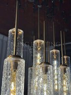Colleena chandelier detail showing glass shade caps, suspension rods, and hammered texture