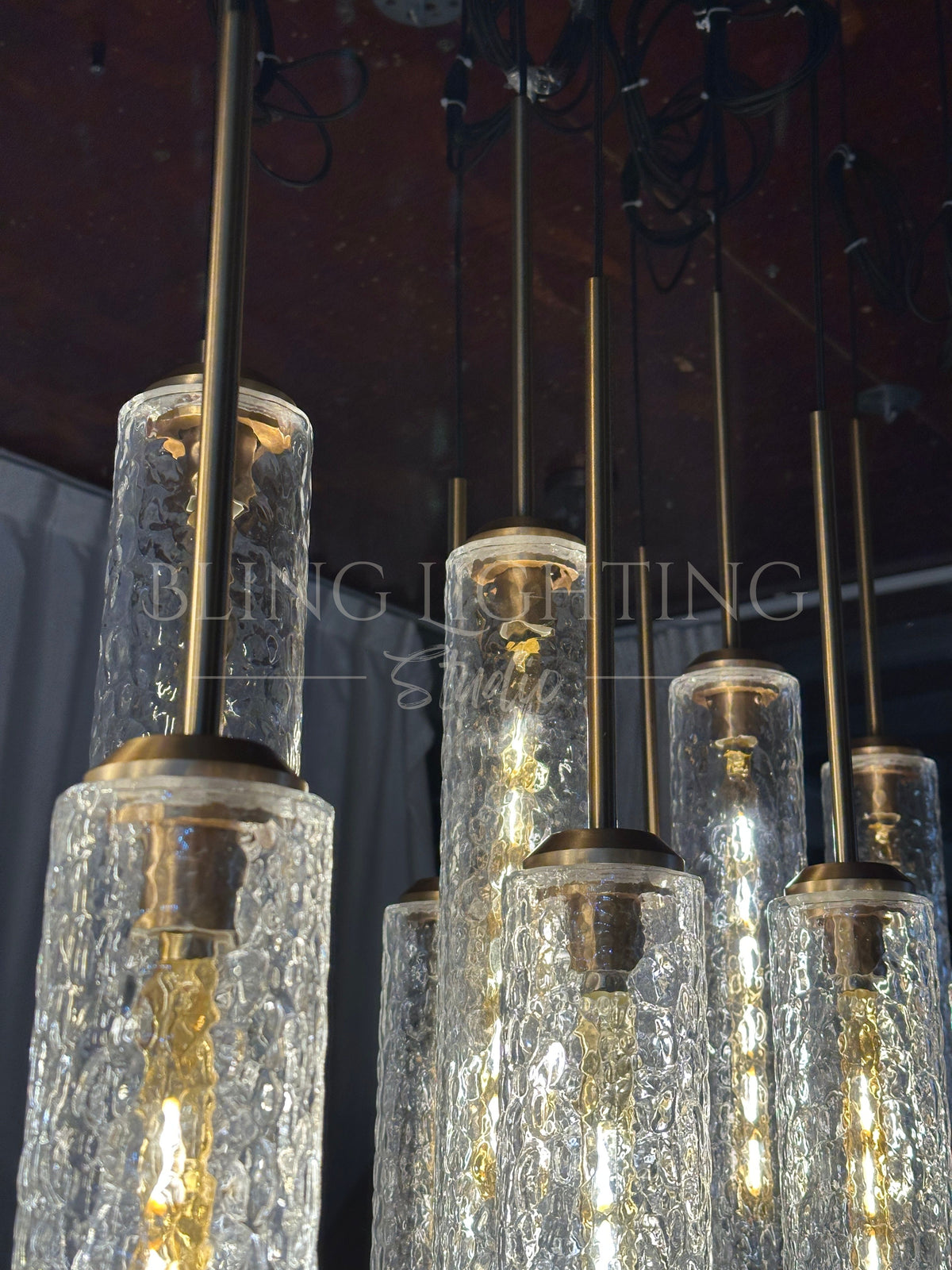 Colleena chandelier detail showing glass shade caps, suspension rods, and hammered texture