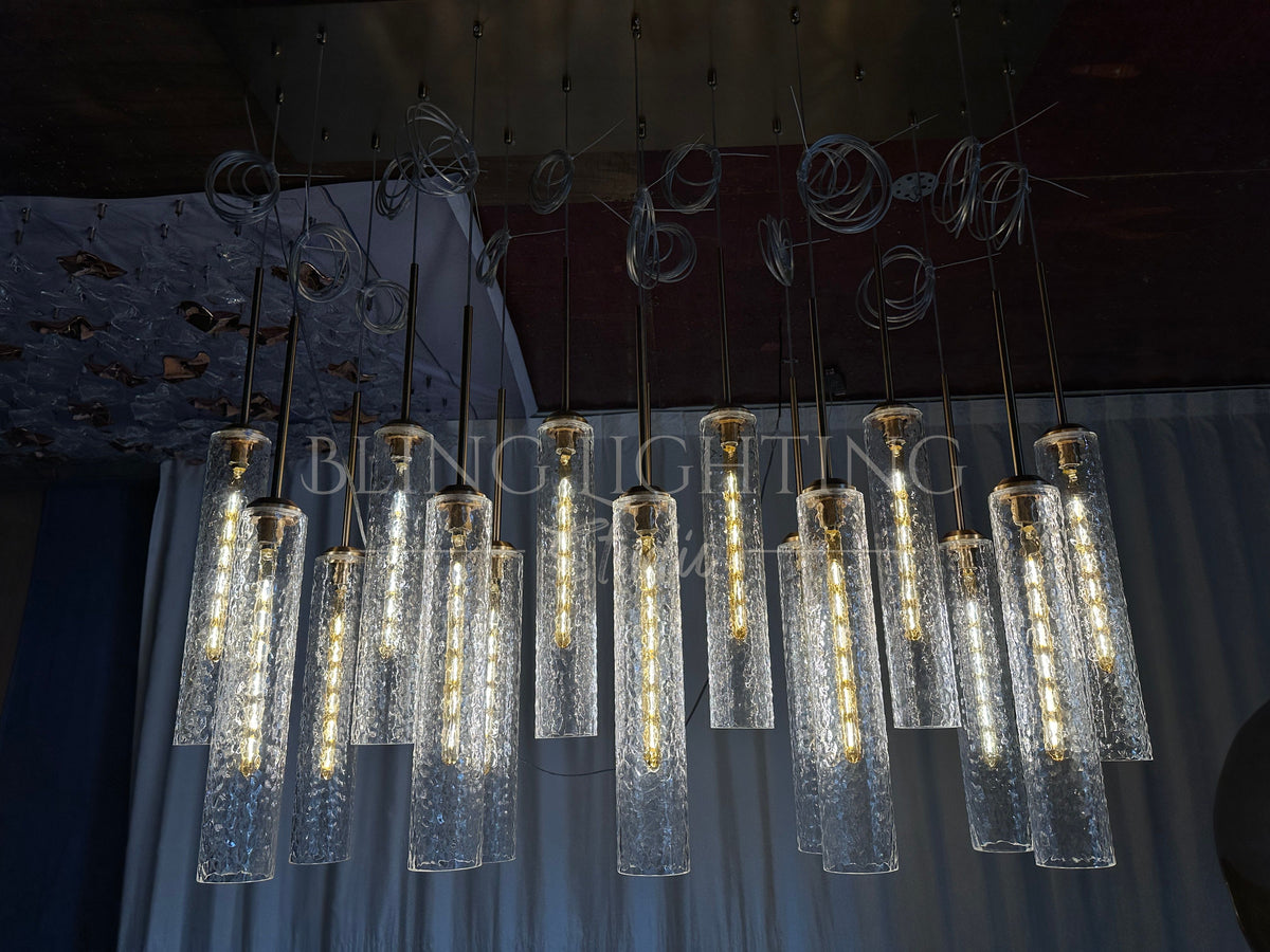 Illuminated Colleena chandelier against a dark backdrop, showing the texture of its hammered glass shades