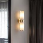 Crestmoor Vanity Alabaster Sconce — product setting and fixture profile, two stone cylinders at opposite ends of a brass frame (view 2)