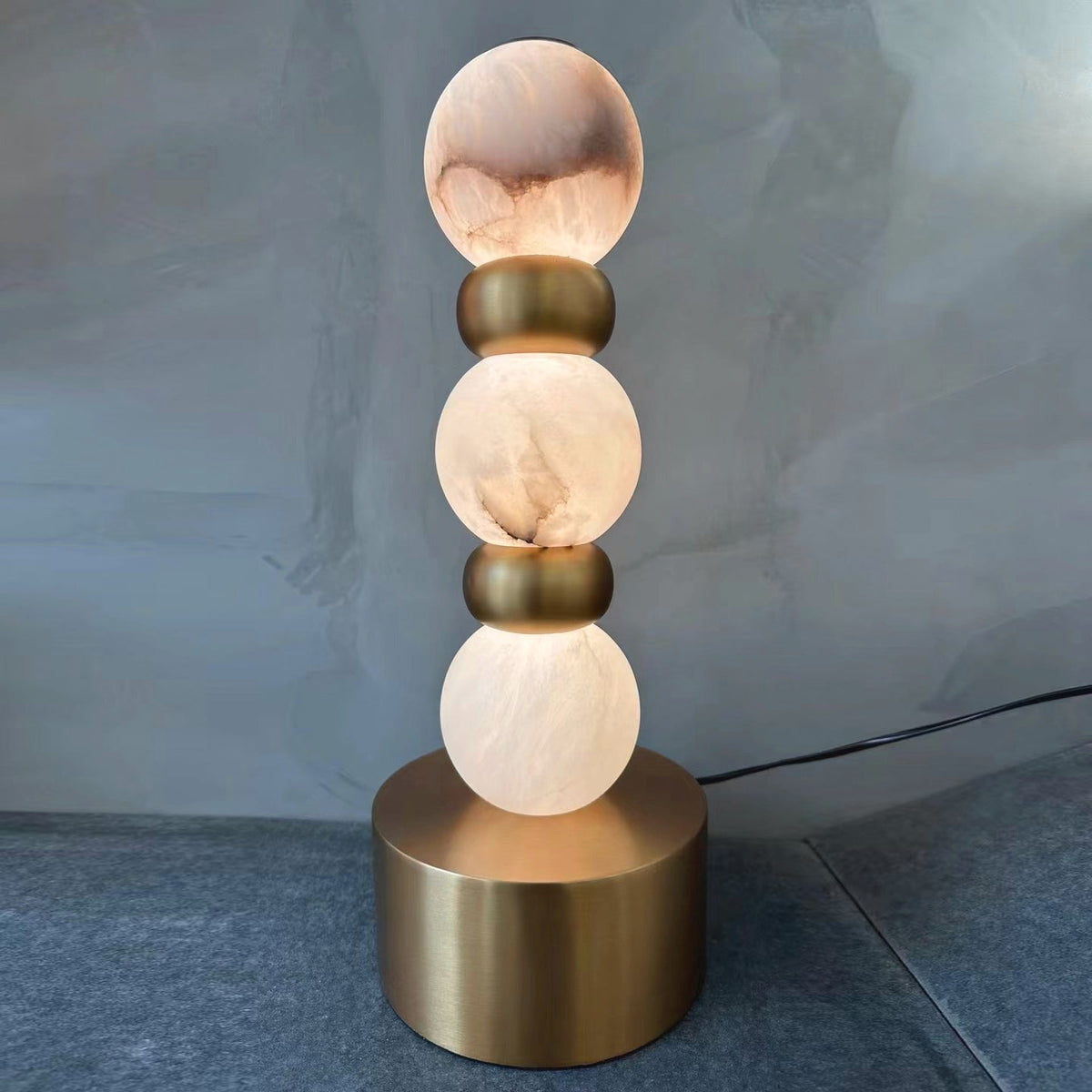 Pearl Xyx Alabaster Table Lamp — product setting and fixture profile, three rounded stone forms above a metal base (view 2)
