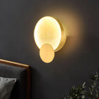 Terra Svet Alabaster Wall Lamp — product setting and fixture profile, a rounded stone diffuser accented by gold-finished circular metal details (view 2)