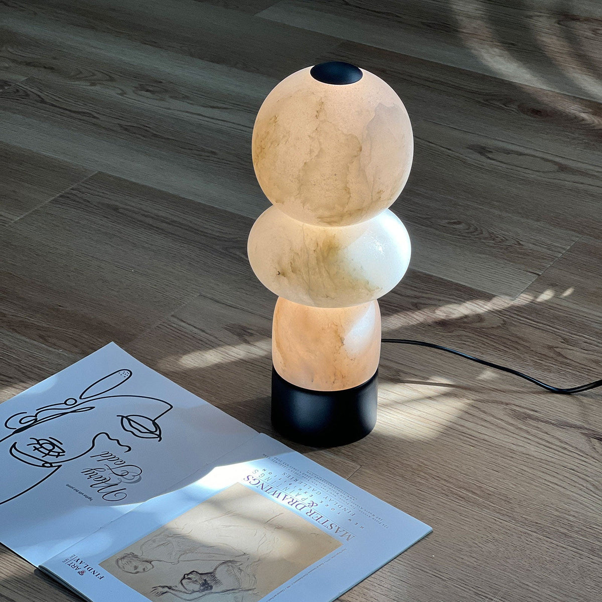 Zinnia Stacked Orb Table Lamp — product setting and fixture profile, rounded stone forms stacked above a dark base (view 2)