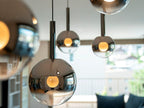 Close up of Cleo Bubble smoke glass globe pendant lights with warm white bulbs