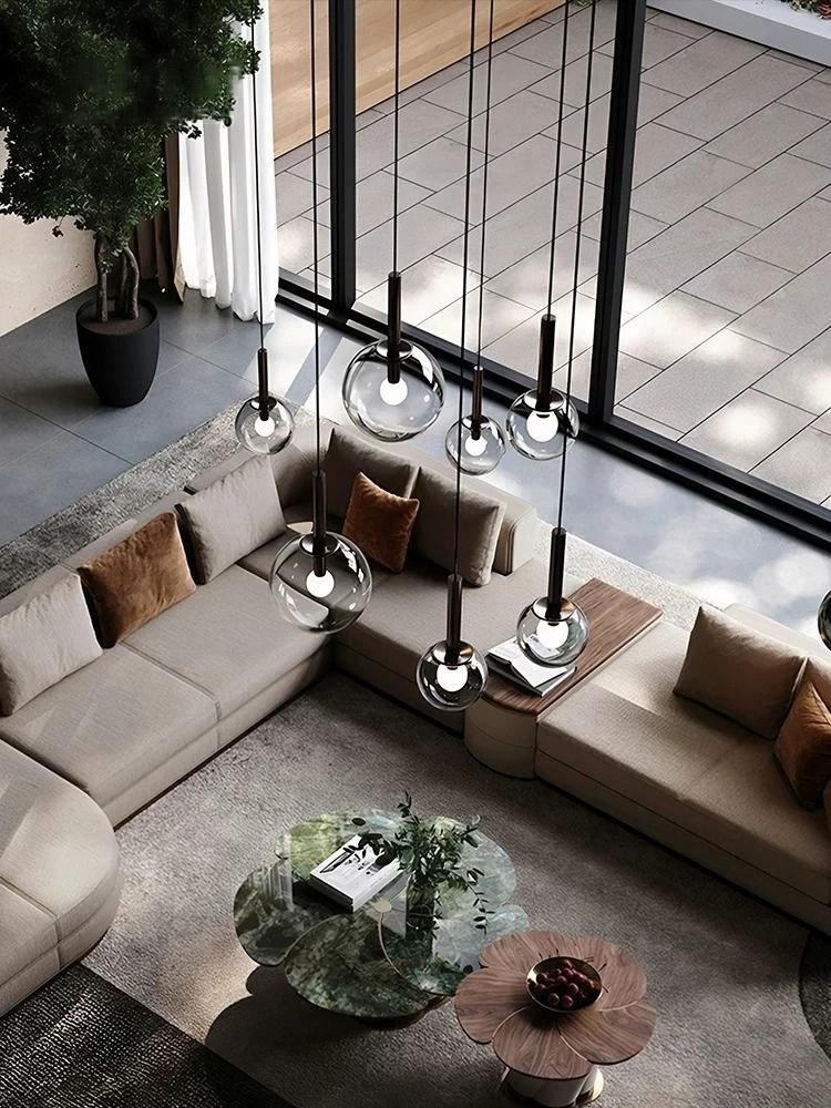 Cleo Bubble Glass Chandelier suspended in a high ceiling living room with glass wall