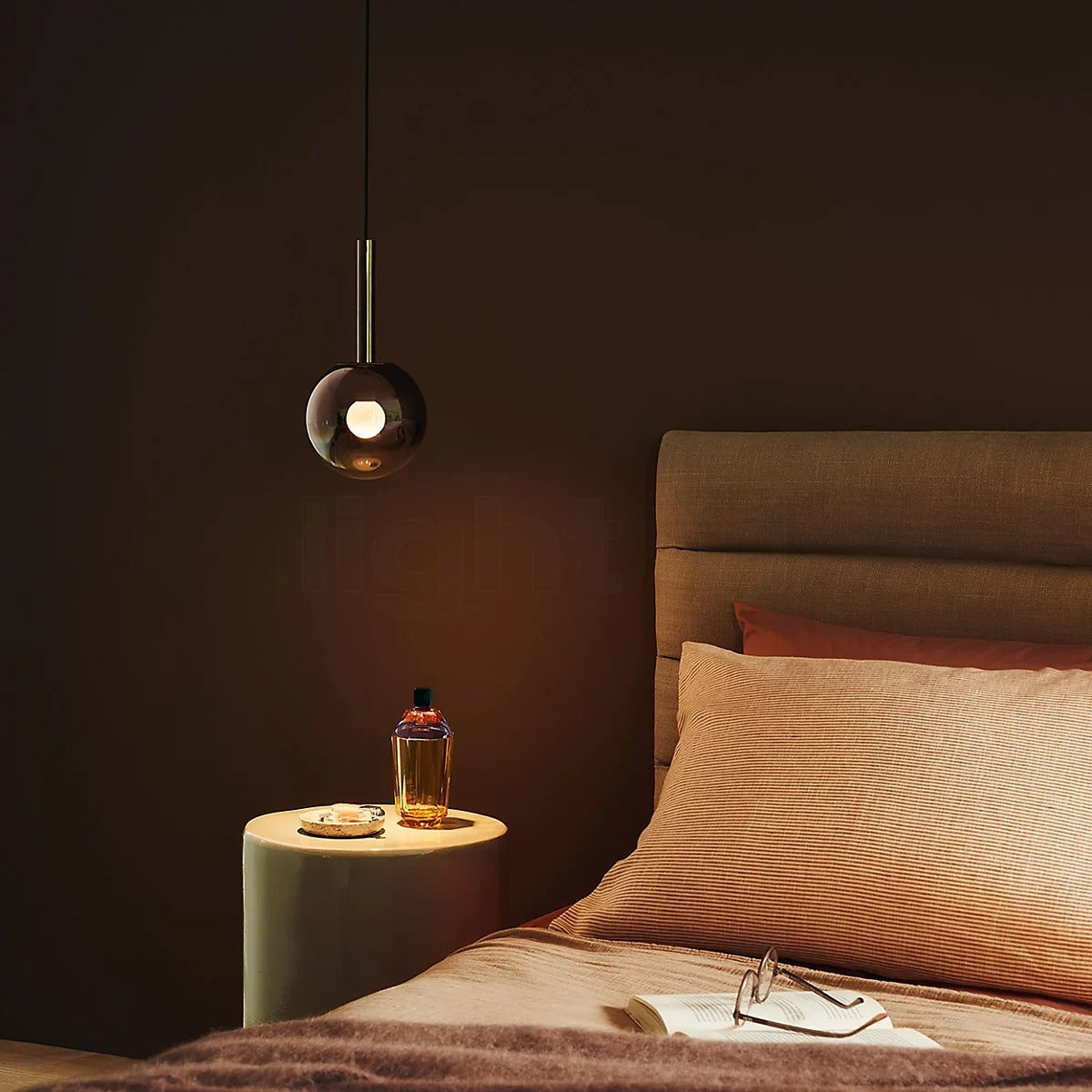 Single Cleo Bubble smoke glass pendant light used as a bedside light in a bedroom