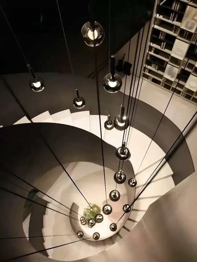 Top view of Cleo Bubble Glass Staircase Chandelier hanging through a spiral stairwell