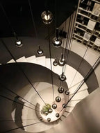 Top view of Cleo Bubble Glass Staircase Chandelier hanging through a spiral stairwell