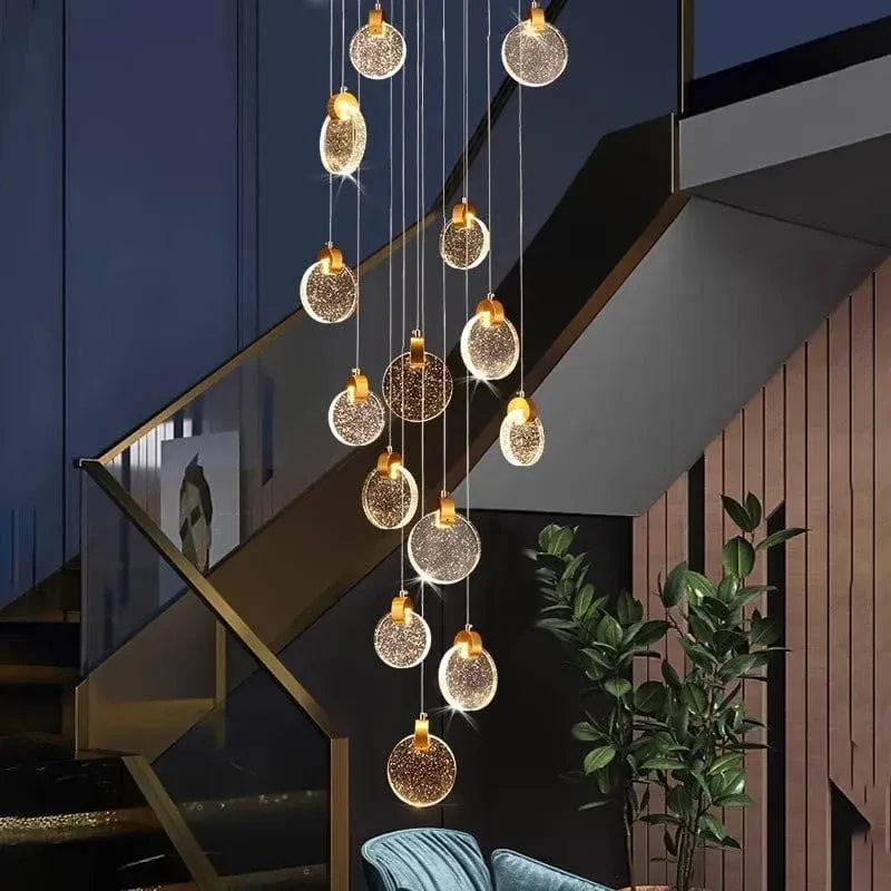 Contemporary LED Chandelier with Crystal Pendant hanging in a dark staircase interior with blue wall and indoor plant