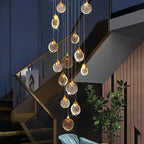 Contemporary LED Chandelier with Crystal Pendant hanging in a dark staircase interior with blue wall and indoor plant