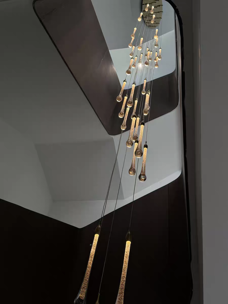 Crystal Raindrop Cascade Staircase Chandelier with staggered clear crystal drops in a tall interior