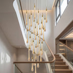 Crystal Raindrop Cascade Staircase Chandelier with gold teardrop crystal pendants in a two-story foyer