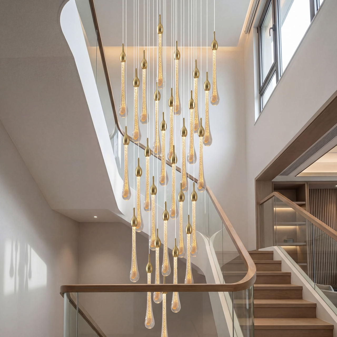 Crystal Raindrop Cascade Staircase Chandelier with gold teardrop crystal pendants in a two-story foyer