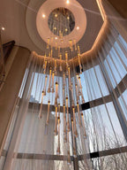Crystal Raindrop Cascade Staircase Chandelier viewed from below with a round gold canopy and elongated crystal pendants