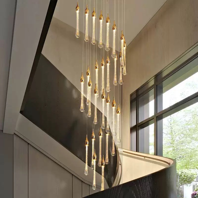Crystal Raindrop Cascade Staircase Chandelier with cascading illuminated crystal drops beside a curved staircase
