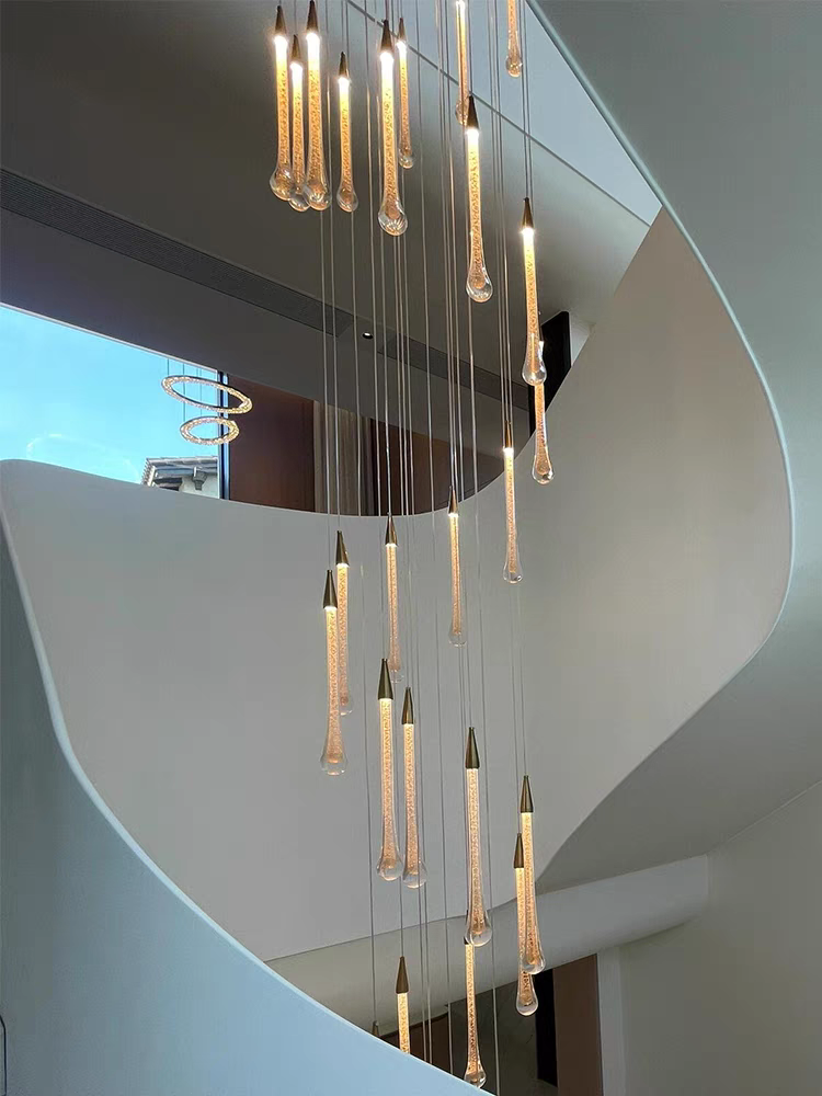 Crystal Raindrop Cascade Chandelier with long clear crystal LED pendants suspended through a multi-level staircase opening