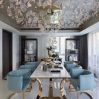Glass Maple Leaf Hanging Light for Staircase installed above a dining room with blue chairs and glass leaves