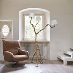 Full view of tall brass branch floor lamp with three white shades