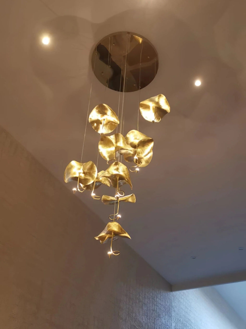 Jenissa Vintage Staircase Chandelier lit from a round ceiling canopy with clustered gold lotus leaf shades