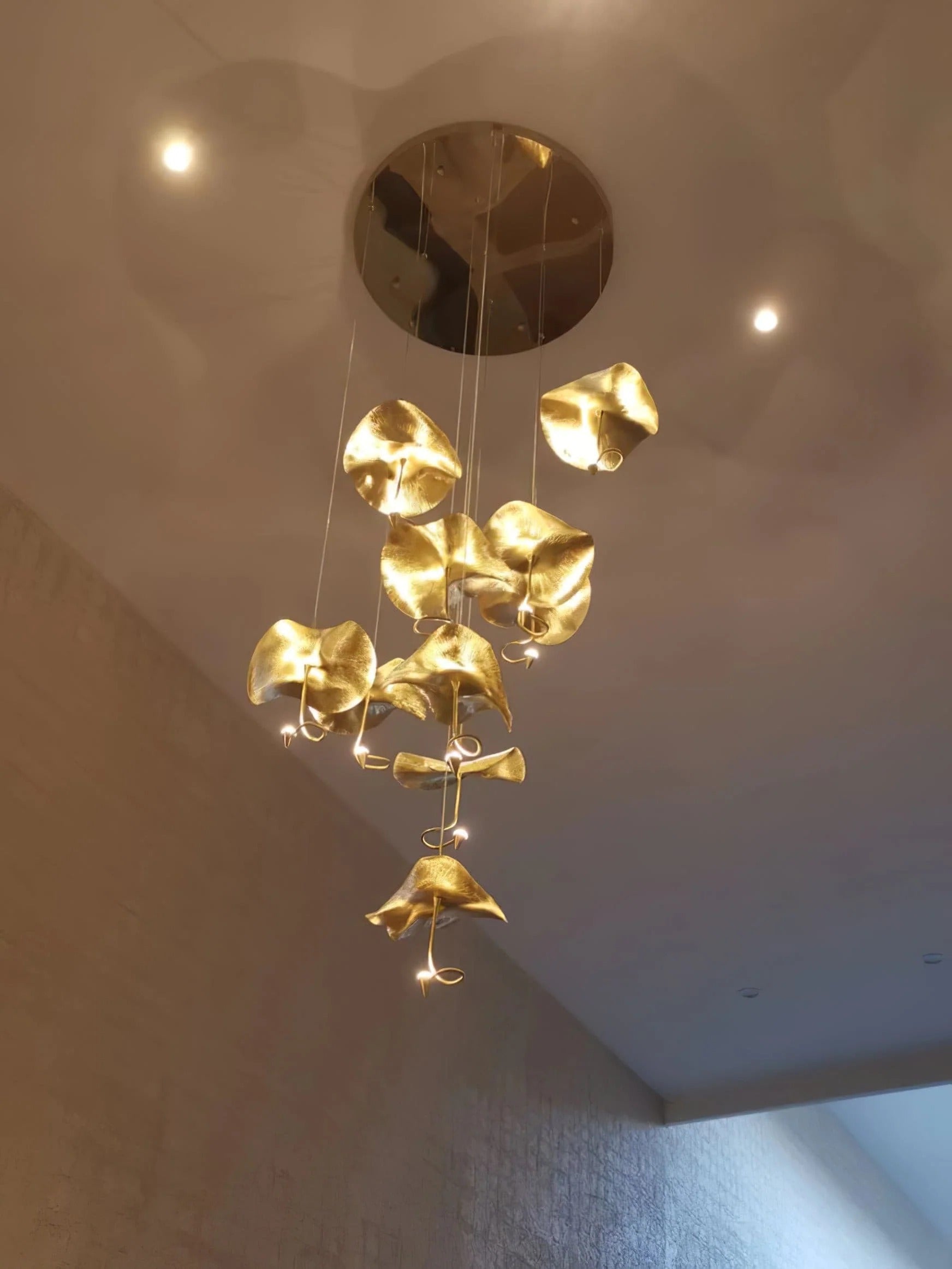 Jenissa Vintage Staircase Chandelier lit from a round ceiling canopy with clustered gold lotus leaf shades